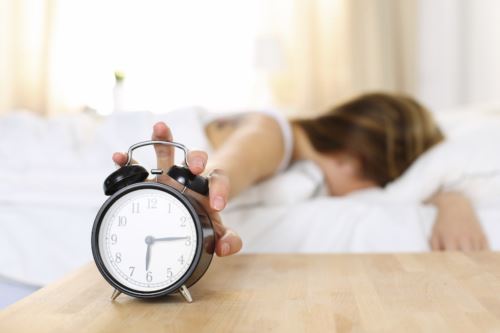 Woman Turning Alarm Clock Off 12498 500x333 1