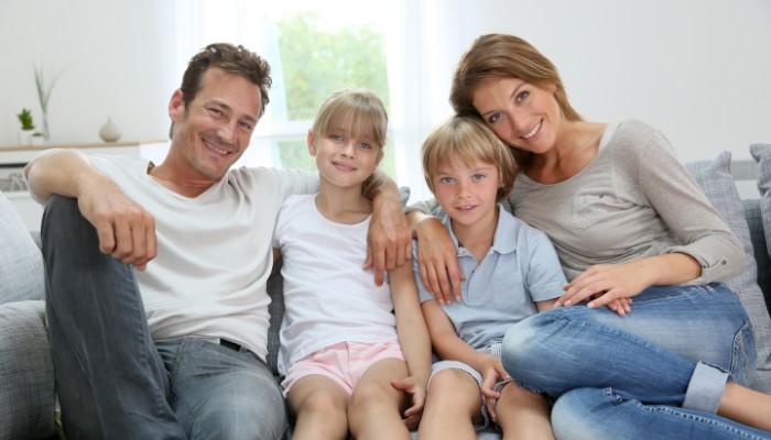 Family Smiling Sitton On Couch Family Smiling Sitton On Couch