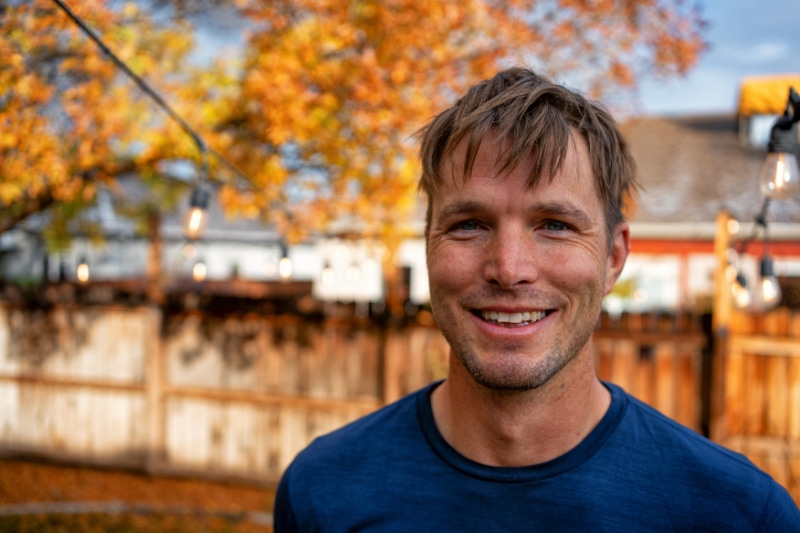 Preparing Your HVAC System for the Fall. Young Blue-Collar Man Portrait In a Back Yard During The Fall Smiling at the Camera.